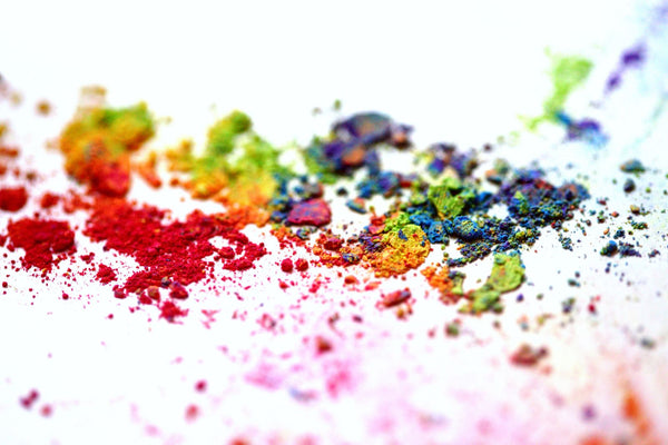 Poudre colorée finement broyée étalée sur une surface blanche, comme un pigment avant sa mise en aquarelle