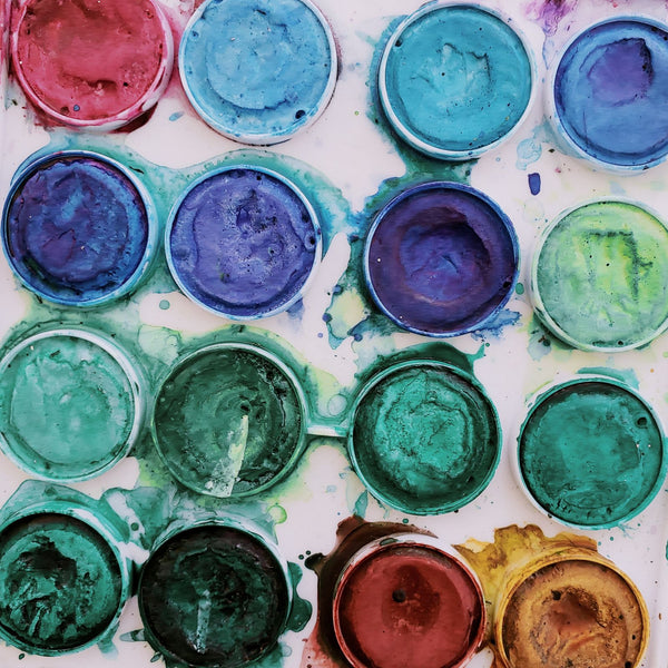 Godets d'aquarelle colorés vus du dessus, comme dans une palette d'aquarelle artisanale